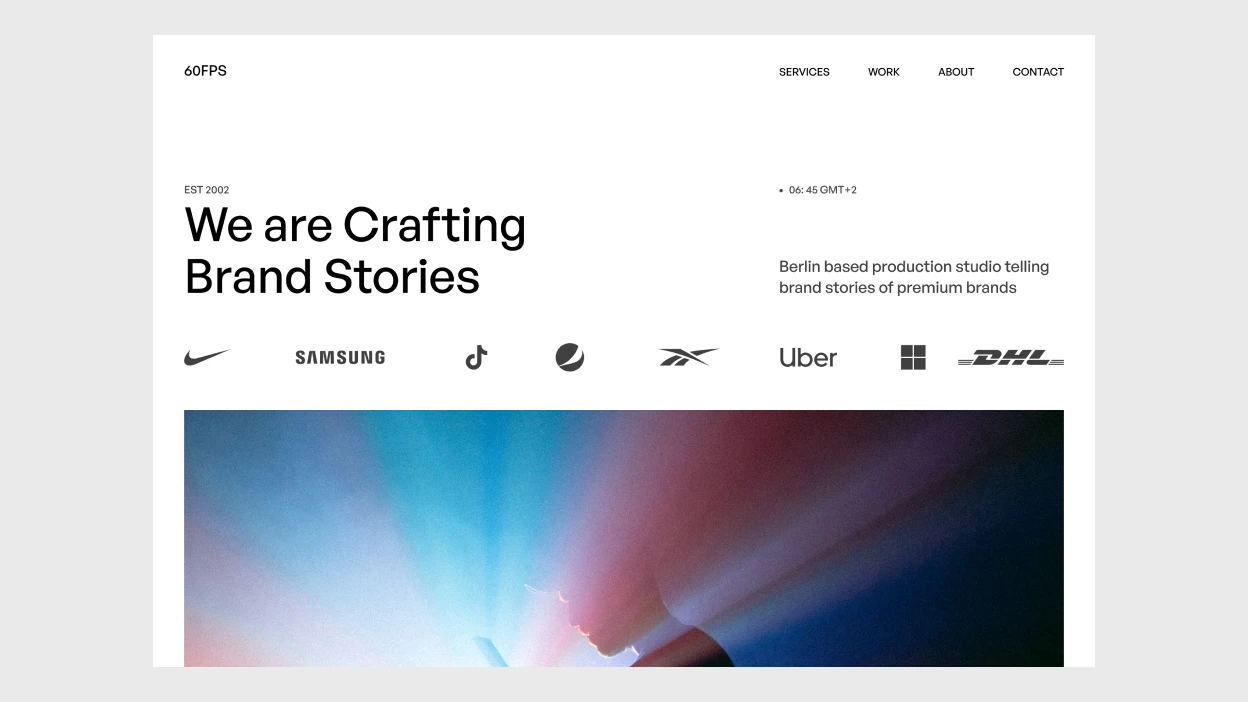 Website homepage with text 'We are Crafting Brand Stories,' logos of brands including Nike, Samsung, TikTok, Uber, and DHL, and a background image of a person illuminated by colorful light rays.